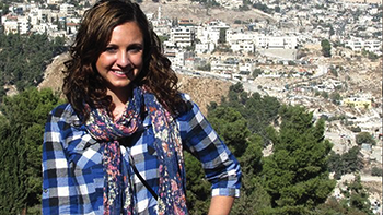 female student standing in foreground with Jerusalem in the background